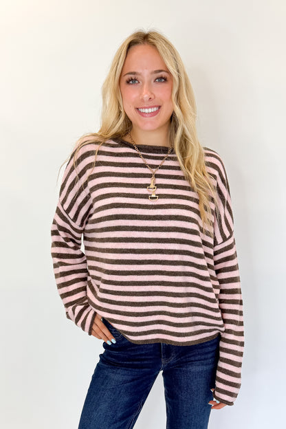 Front view of woman wearing Swagger Boutique’s Pink &amp; Brown Striped Sweater with jeans against white studio background.