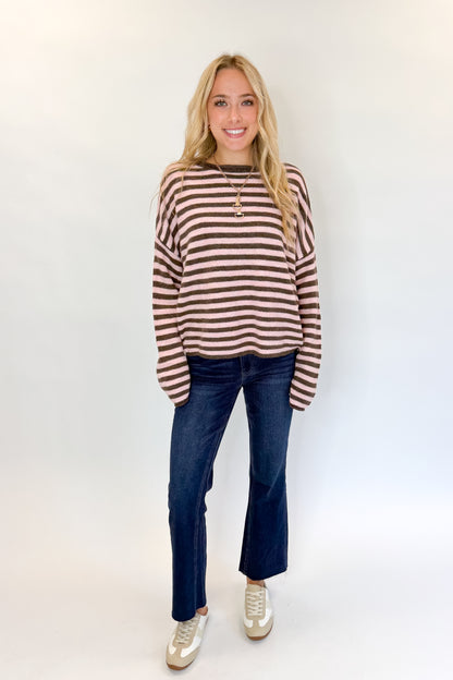 Front view of woman wearing Swagger Boutique’s Pink &amp; Brown Striped Sweater with jeans against white studio background.