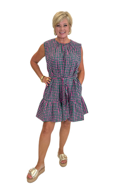 Front view of woman wearing Swagger Boutique’s Pink &amp; Green Polka Dot Mini Dress with sandals against white studio background.