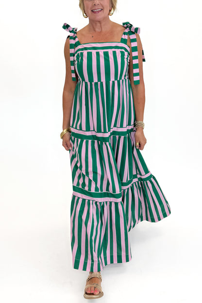 Front detail view of woman wearing Swagger Boutique’s Pink &amp; Green Striped Tiered Maxi Dress with sandals against white studio background.