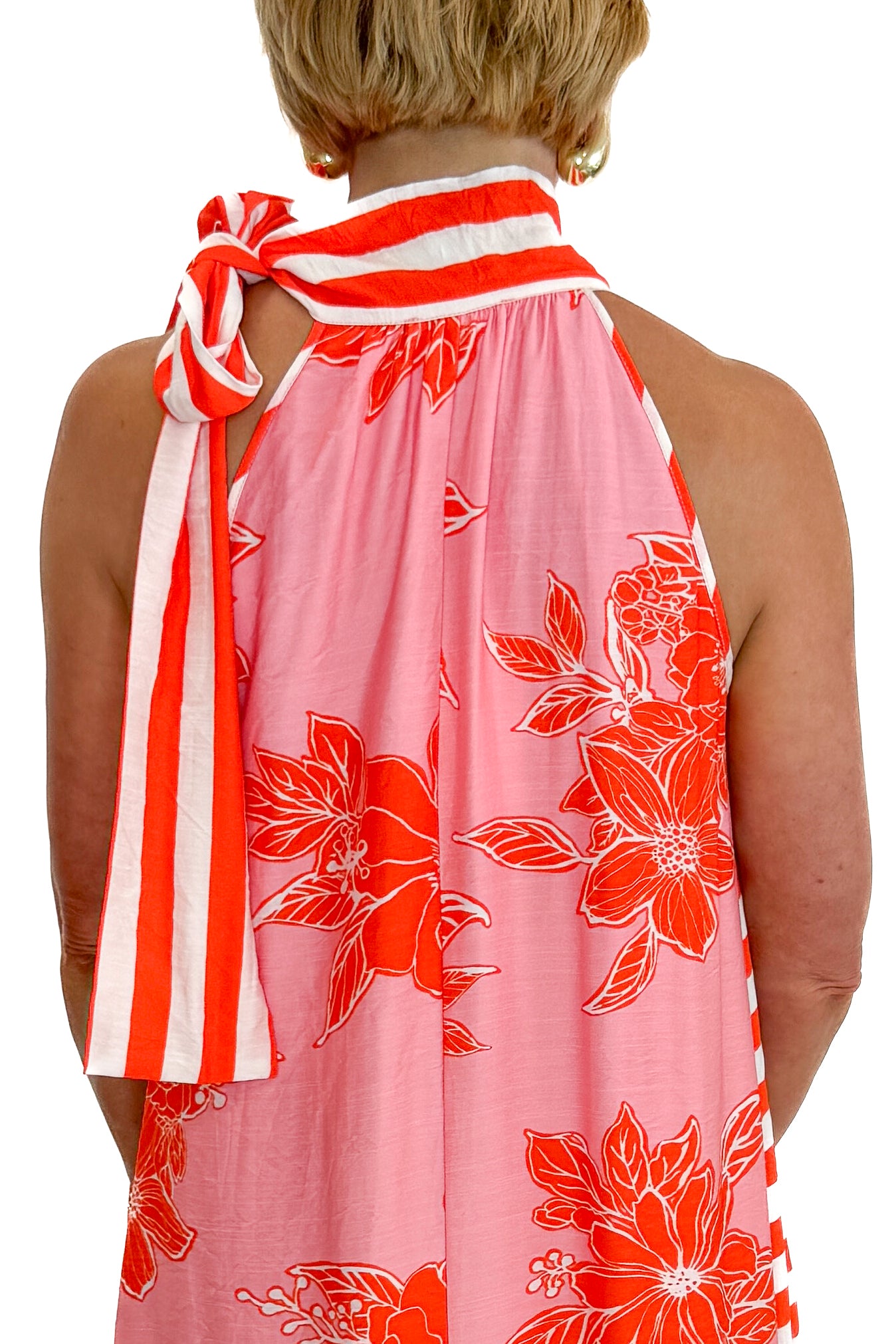 Back detail view of woman wearing Swagger Boutique’s Pink &amp; Orange Floral &amp; Stripe Maxi Dress by Entro with heels against white studio background.