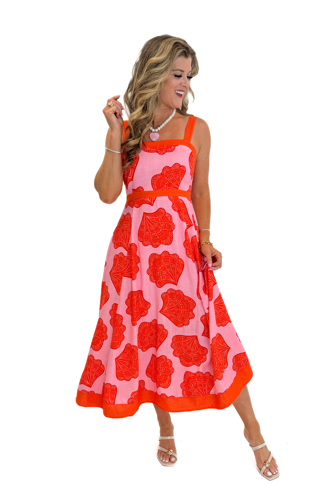 Front view of woman wearing Swagger Boutique’s Pink &amp; Orange Printed Midi Dress by Entro with sandals against white studio background.