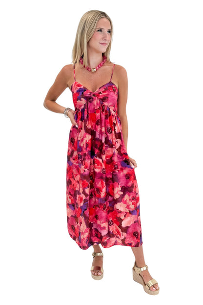 Front view of woman wearing Swagger Boutique’s Pink &amp; Red Floral Midi Dress with sandals against white studio background.