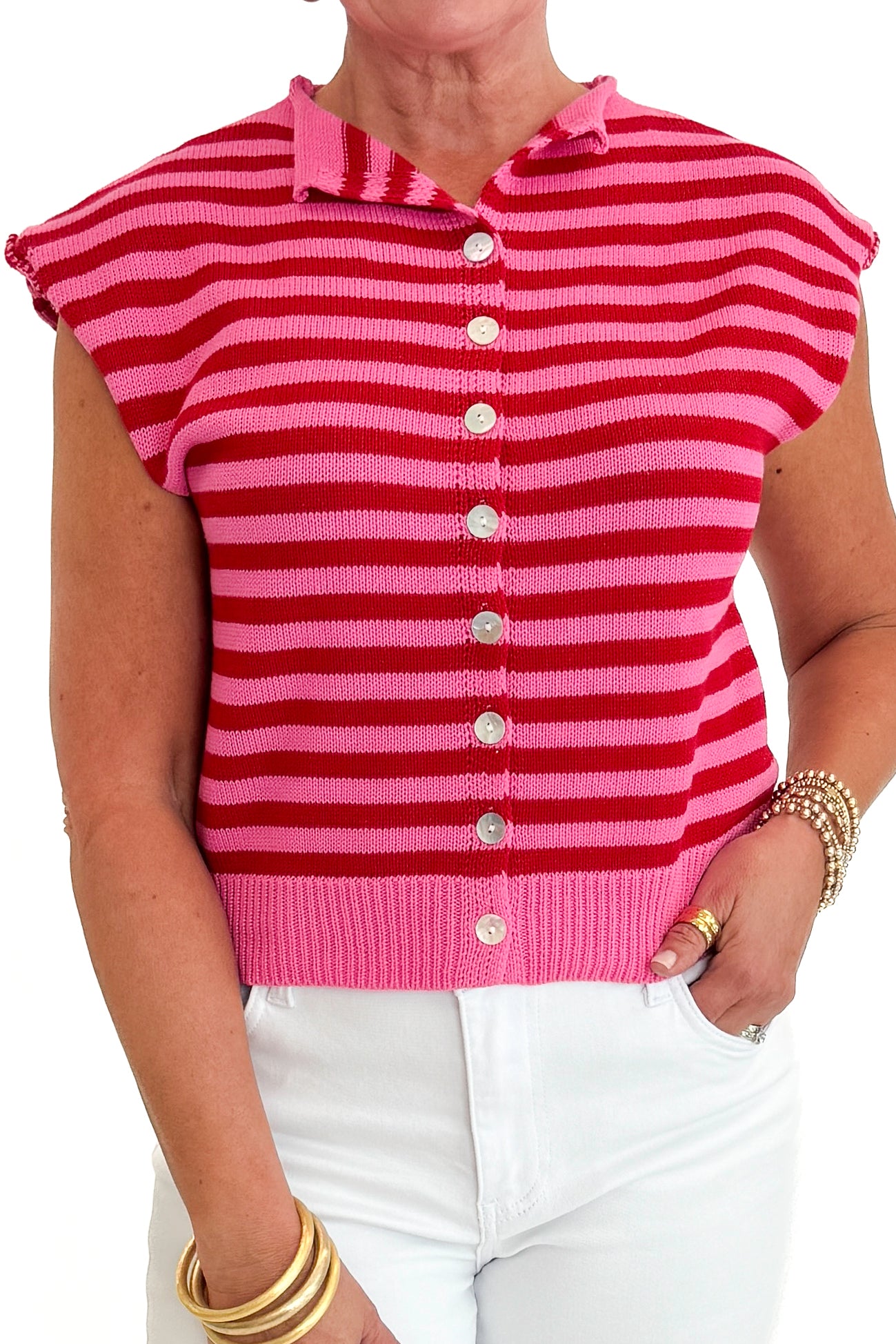 Front detail view of woman wearing Swagger Boutique’s Pink &amp; Red Striped Sleeveless Button Up Sweater by Entro with jeans against white studio background.