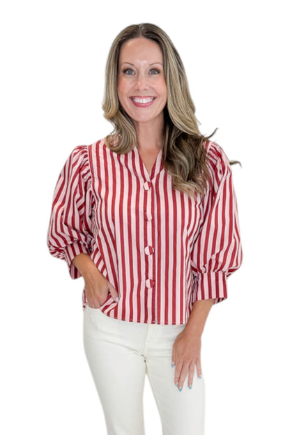 Front view of woman wearing Swagger Boutique’s Pink &amp; Wine Striped Puff Sleeve Top with jeans against white studio background.