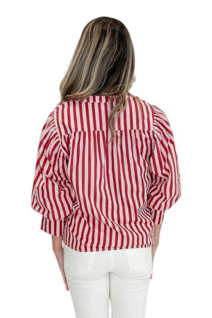 Back view of woman wearing Swagger Boutique’s Pink &amp; Wine Striped Puff Sleeve Top with jeans against white studio background.