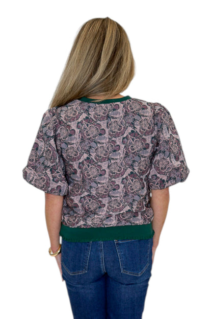 Back view of woman wearing Swagger Boutique’s Plum Jacquard Bubble Sleeve Top with jeans against white studio background.