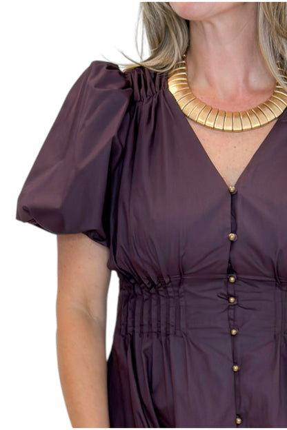 Front detail view of woman wearing Swagger Boutique’s Plum Pleated Waist Midi Dress by Entro with heels against white studio background.