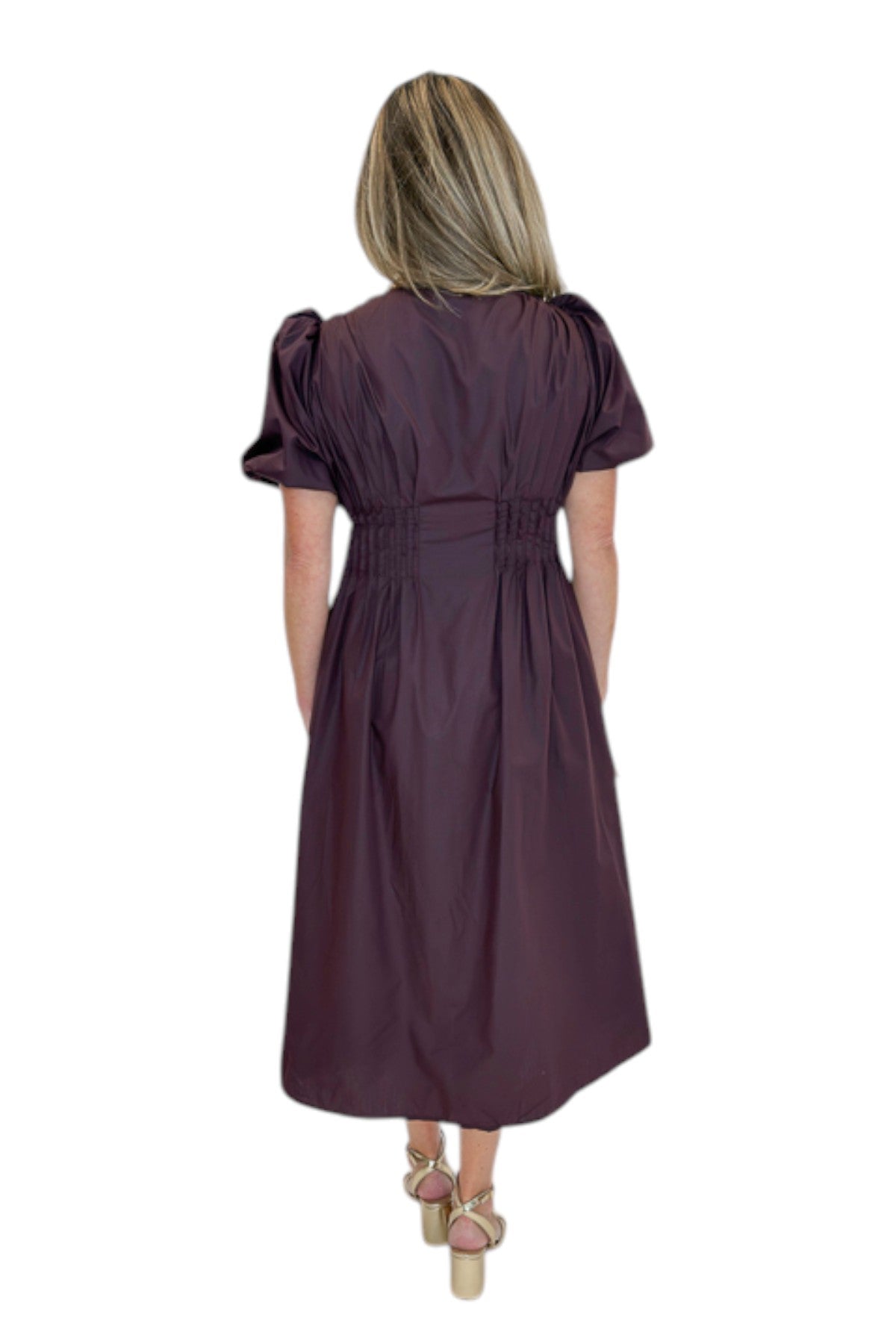 Back view of woman wearing Swagger Boutique’s Plum Pleated Waist Midi Dress by Entro with heels against white studio background.