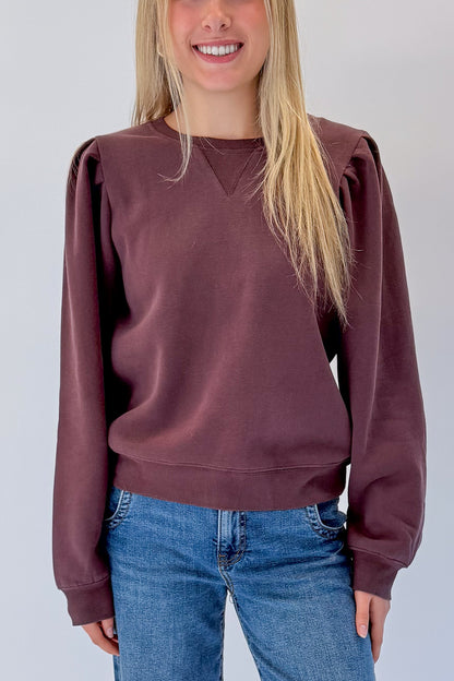 Front detail view of woman wearing Swagger Boutique’s Plum Puff Sleeve Sweatshirt with jeans against white studio background.