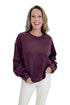 Front view of woman wearing Swagger Boutique’s Plum Textured Sweatshirt with jeans against white studio background.