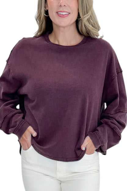 Front detail view of woman wearing Swagger Boutique’s Plum Textured Sweatshirt with jeans against white studio background.