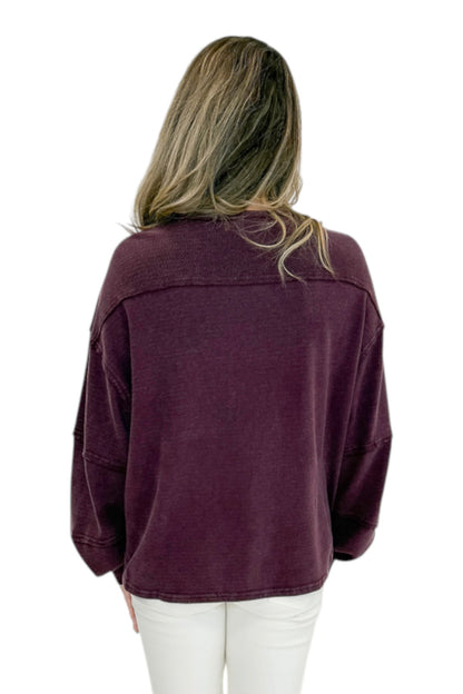 Back view of woman wearing Swagger Boutique’s Plum Textured Sweatshirt with jeans against white studio background.
