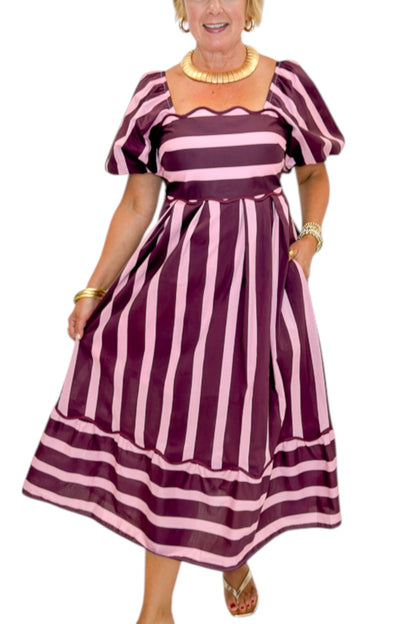 Front detail view of woman wearing Swagger Boutique’s Plum &amp; Pink Striped Midi Dress by Entro with sandals against white studio background.