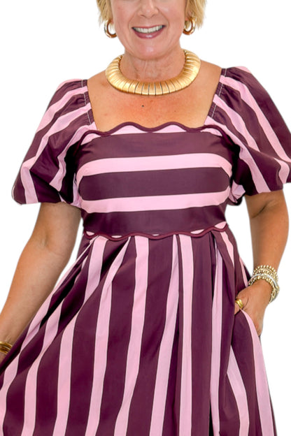 Front detail view of woman wearing Swagger Boutique’s Plum &amp; Pink Striped Midi Dress by Entro with sandals against white studio background.
