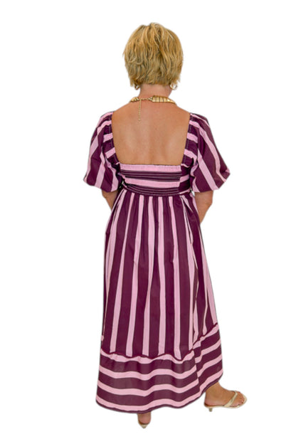 Back view of woman wearing Swagger Boutique’s Plum &amp; Pink Striped Midi Dress by Entro with sandals against white studio background.