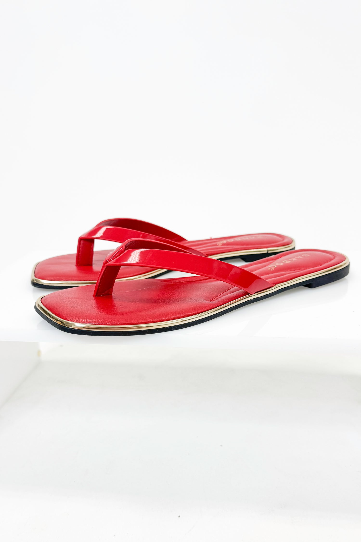 Pointer- Red Flip Flops against studio background side view.