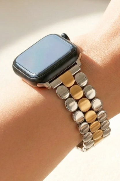 A close-up of a smartwatch with a two-tone metal link band worn on a person&