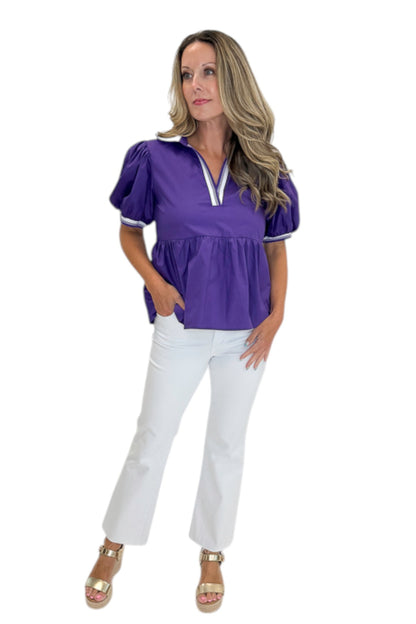 Front view of woman wearing Swagger Boutique’s Purple Collared Peplum Top with jeans against white studio background.