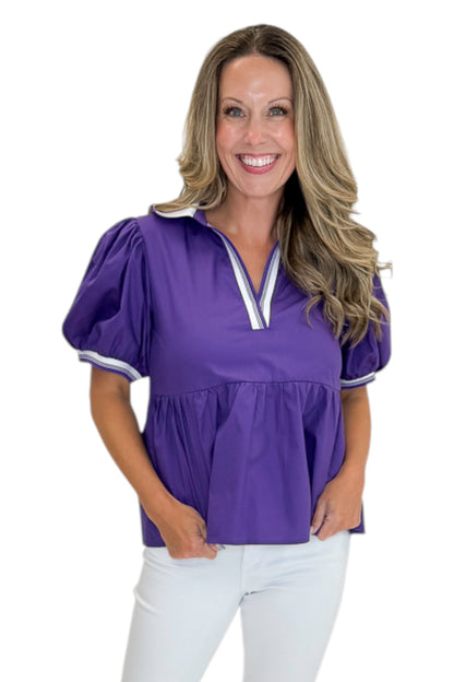 Front view of woman wearing Swagger Boutique’s Purple Collared Peplum Top with jeans against white studio background.