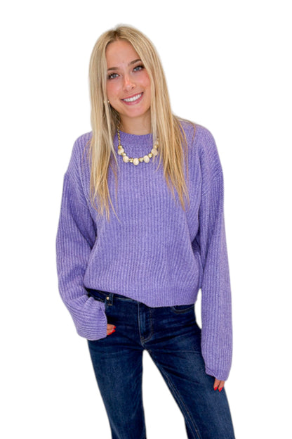 Front view of woman wearing Swagger Boutique’s Purple Ribbed sweater with jeans against white studio background.
