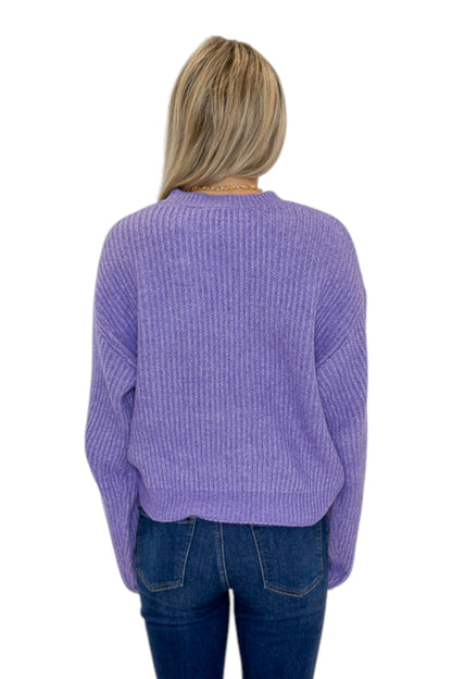Back view of woman wearing Swagger Boutique’s Purple Ribbed sweater with jeans against white studio background.