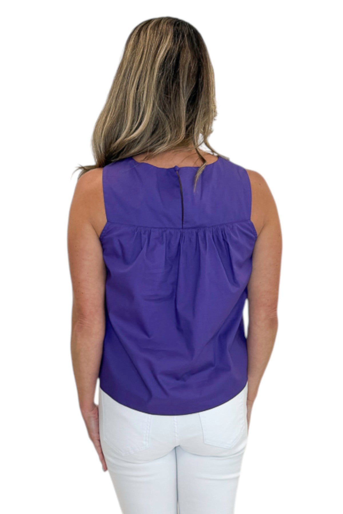 Back view of woman wearing Swagger Boutique’s Purple Ruffle Tank with jeans against white studio background.