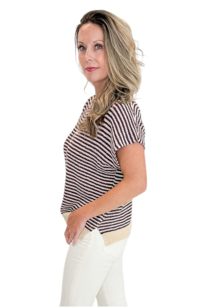 Side view of woman wearing Swagger Boutique’s Purple &amp; Beige Striped Sleeveless Sweater with jeans against white studio background.