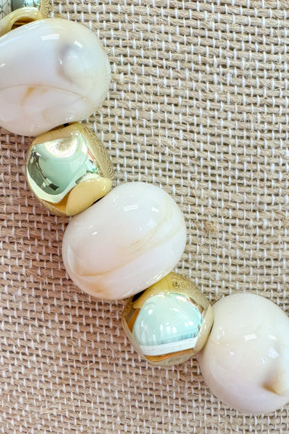 Necklace with large beads on a textured beige background