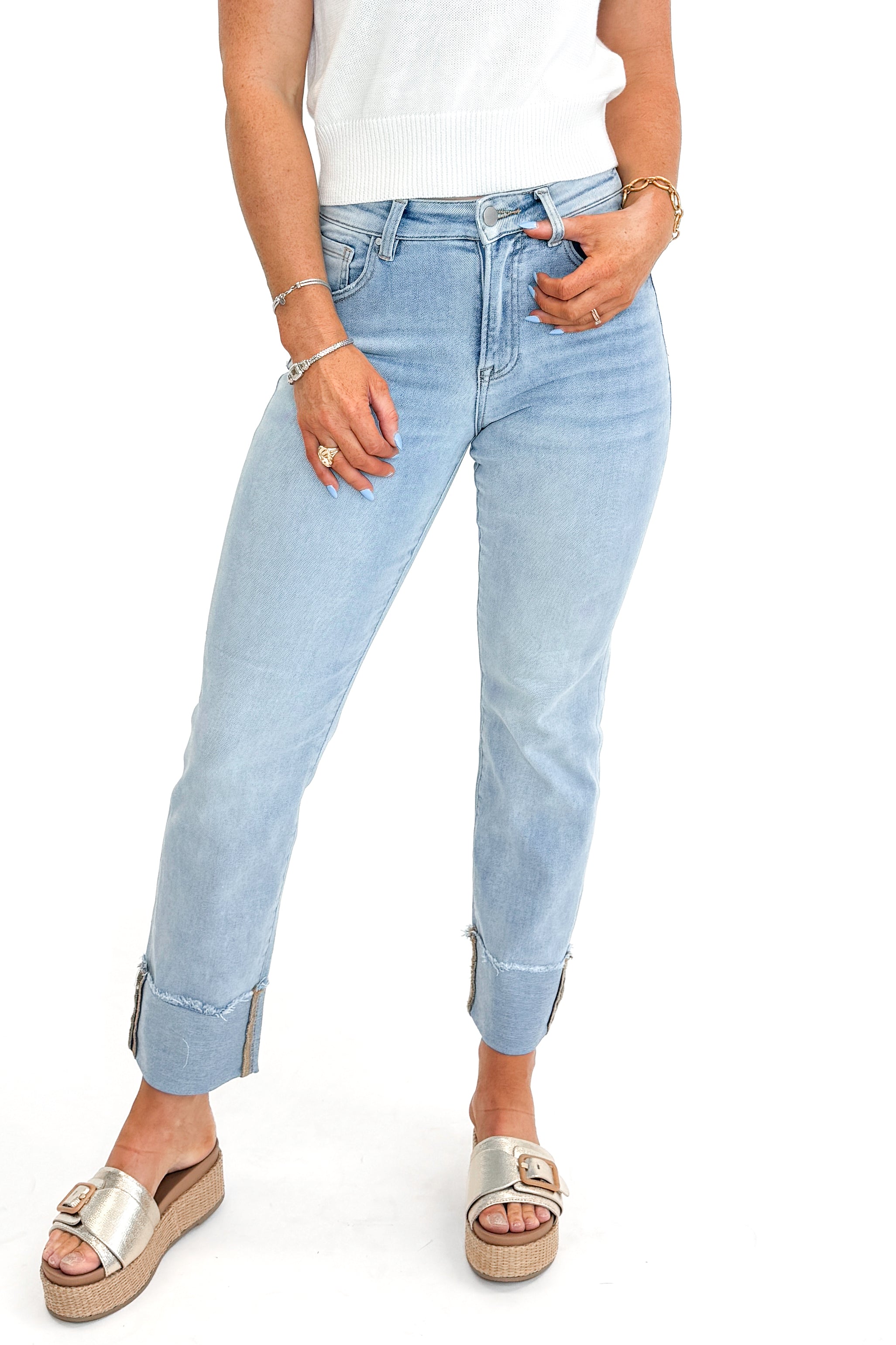 Front view of woman wearing sweater with Light Wash Relaxed Straight Jeans by Risen against white studio background.
