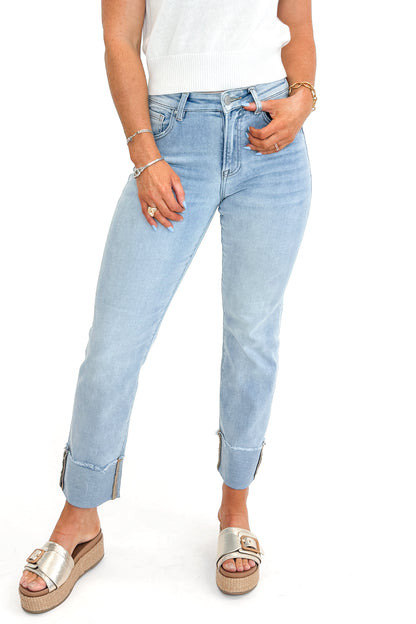 Front view of woman wearing sweater with Light Wash Relaxed Straight Jeans by Risen against white studio background.