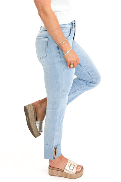 Side view of woman wearing sweater with Light Wash Relaxed Straight Jeans by Risen against white studio background.
