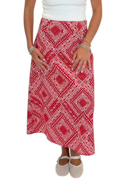 Front detail view of woman wearing Swagger Boutique’s Red Bandana Print Midi Skirt with white top against white studio background.