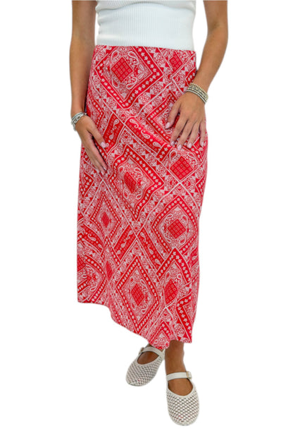 Front detail view of woman wearing Swagger Boutique’s Red Bandana Print Midi Skirt with white top against white studio background.