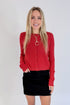 Front view of woman wearing Swagger Boutique’s Red Button Up Cardigan with Black Denim Mini Skirt by Just Black Denim against white studio background.