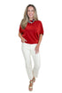Front view of woman wearing Swagger Boutique’s Red Dolman Sleeve Top with jeans against white studio background.