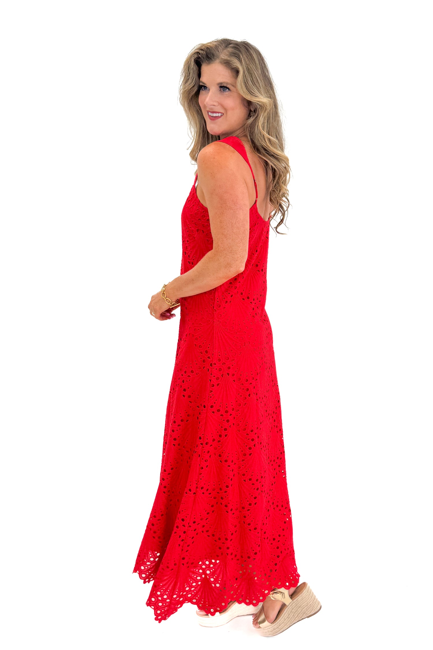 Side view of woman wearing Swagger Boutique’s Red Embroidered Maxi Dress with sandals against white studio background.