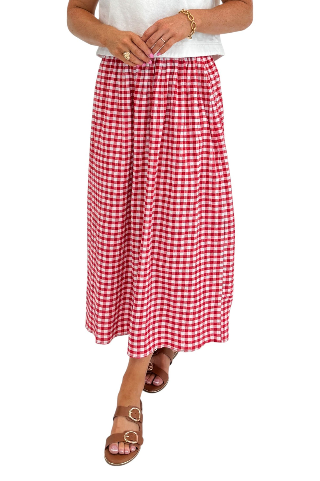 Front detail view of woman wearing Swagger Boutique’s Red Gingham Flowy Midi Skirt with White Denim Tank against white studio background.