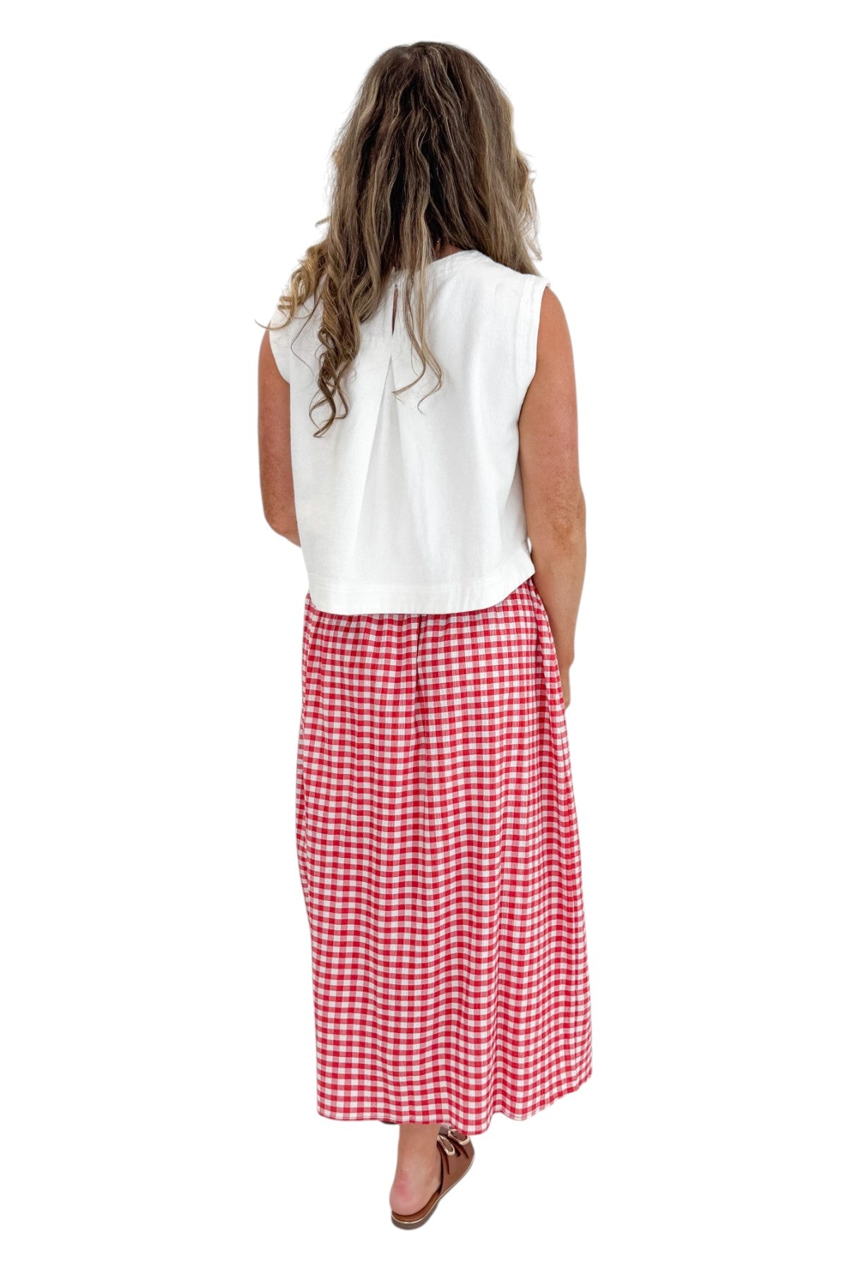 Back view of woman wearing Swagger Boutique’s Red Gingham Flowy Midi Skirt with White Denim Tank against white studio background.