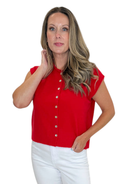 Front view of woman wearing Swagger Boutique’s Red Sleeveless Button Up Sweater with jeans against white studio background.