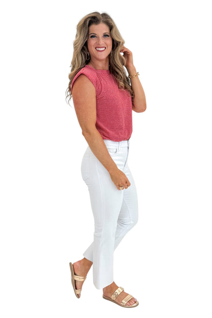 Side view of woman wearing Swagger Boutique’s Red Striped Bubble Hem Sleeveless Top with jeans against white studio background.