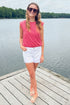 Front view of woman wearing Swagger Boutique’s Red Striped Bubble Hem Sleeveless Top with jean shorts standing on a dock at the lake.