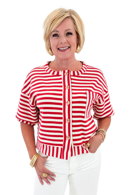 Front view of woman wearing Swagger Boutique’s Red Striped Short Sleeve Button Up Top with jeans against white studio background.