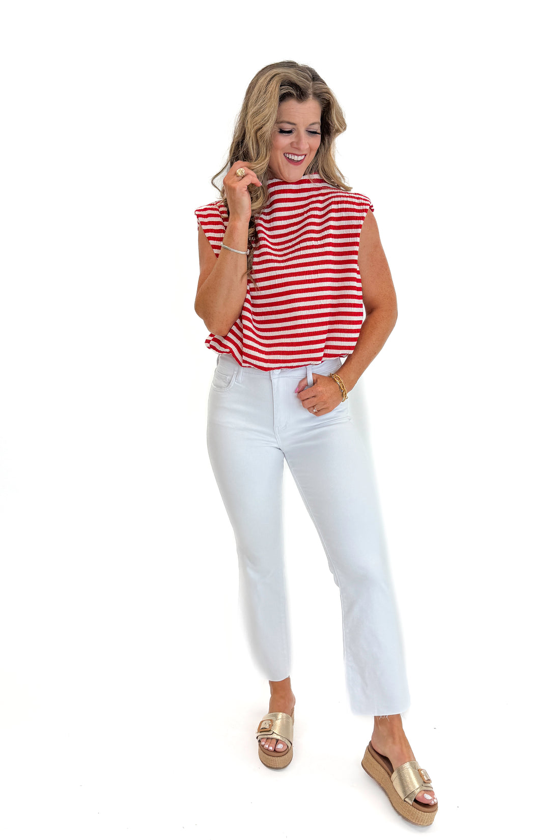 Front view of woman wearing Swagger Boutique’s Red Striped Sleeveless High Neck Top with jeans against white studio background.