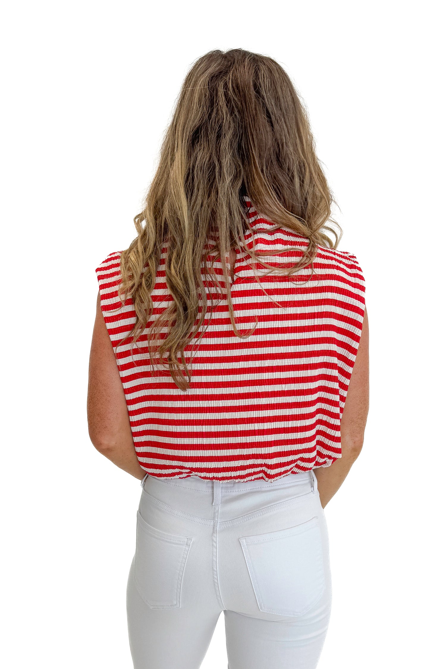 Back view of woman wearing Swagger Boutique’s Red Striped Sleeveless High Neck Top with jeans against white studio background.