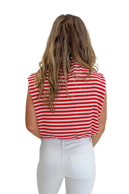 Back view of woman wearing Swagger Boutique’s Red Striped Sleeveless High Neck Top with jeans against white studio background.
