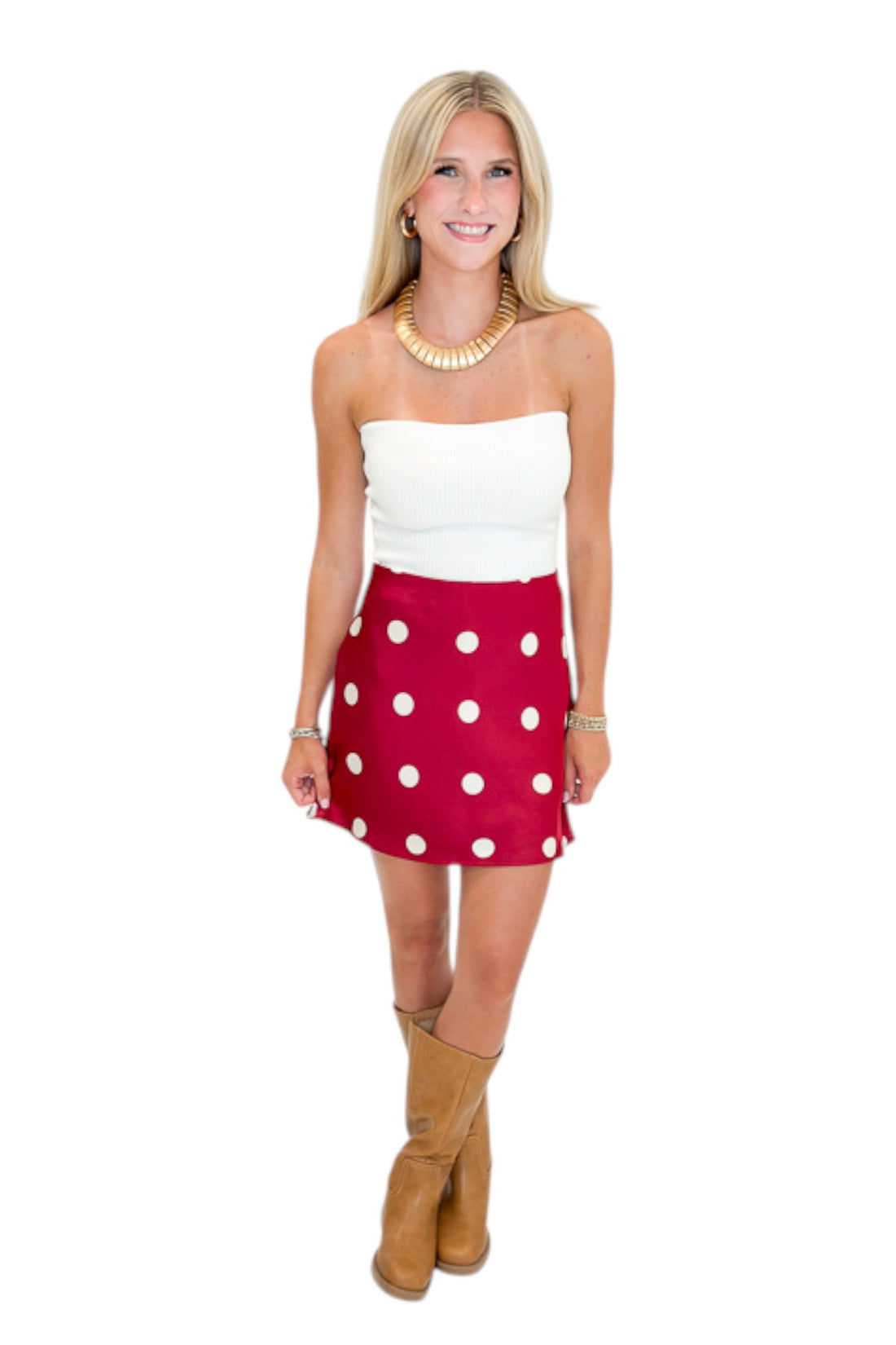 Front view of woman wearing Swagger Boutique’s white top with Red &amp; Cream Polka Dot Satin Mini Skirt against white studio background.