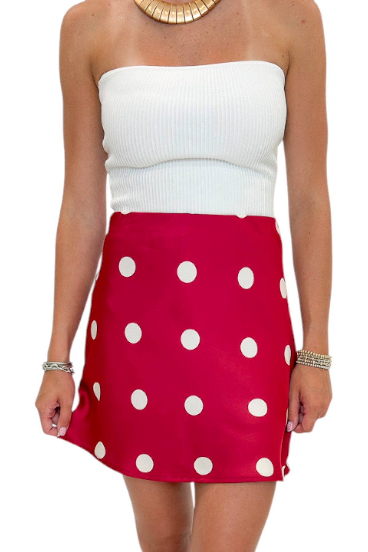Front detail view of woman wearing Swagger Boutique’s white top with Red &amp; Cream Polka Dot Satin Mini Skirt against white studio background.