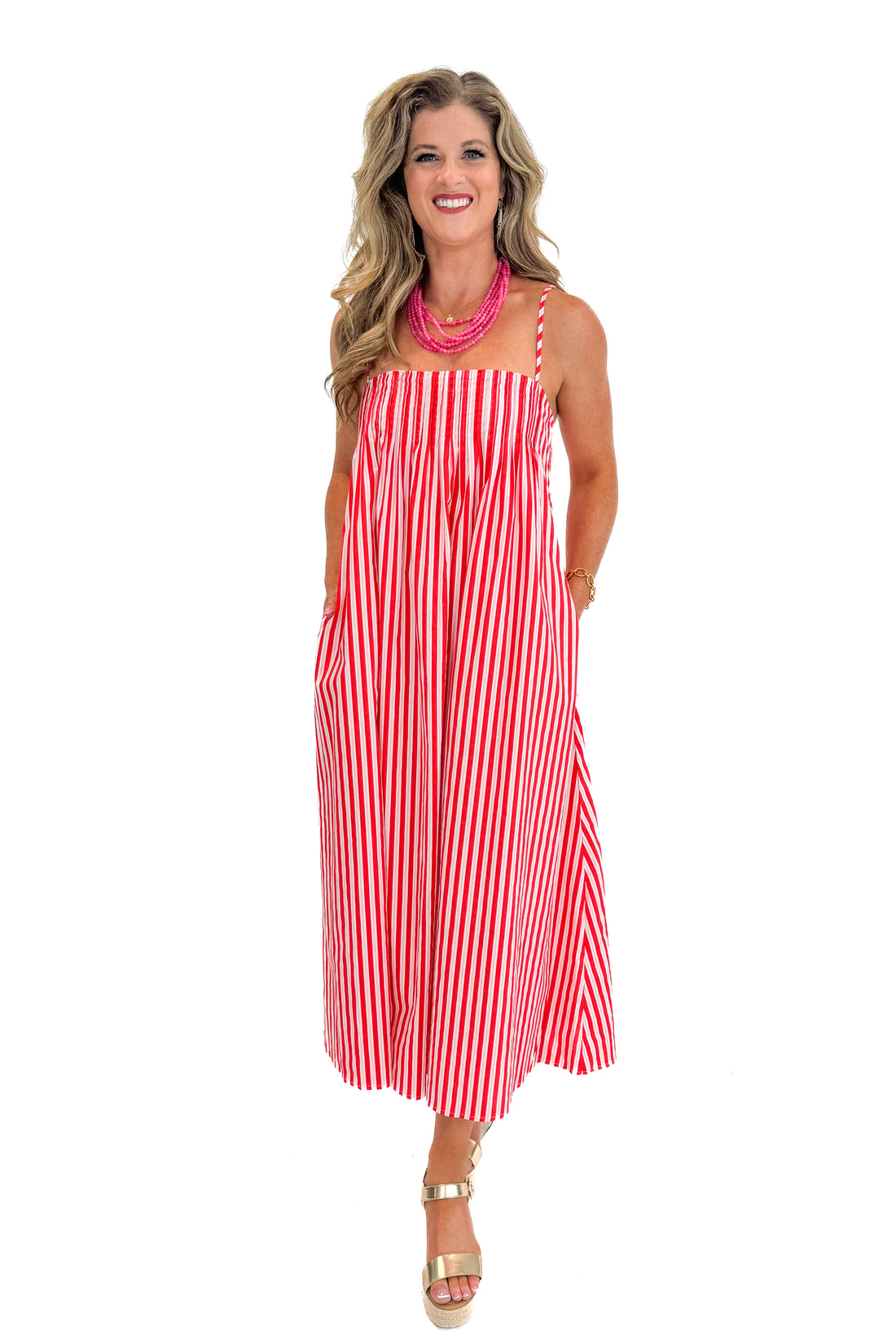 Front view of woman wearing Swagger Boutique’s Red &amp; Pink Striped Maxi Dress with sandals against white studio background.