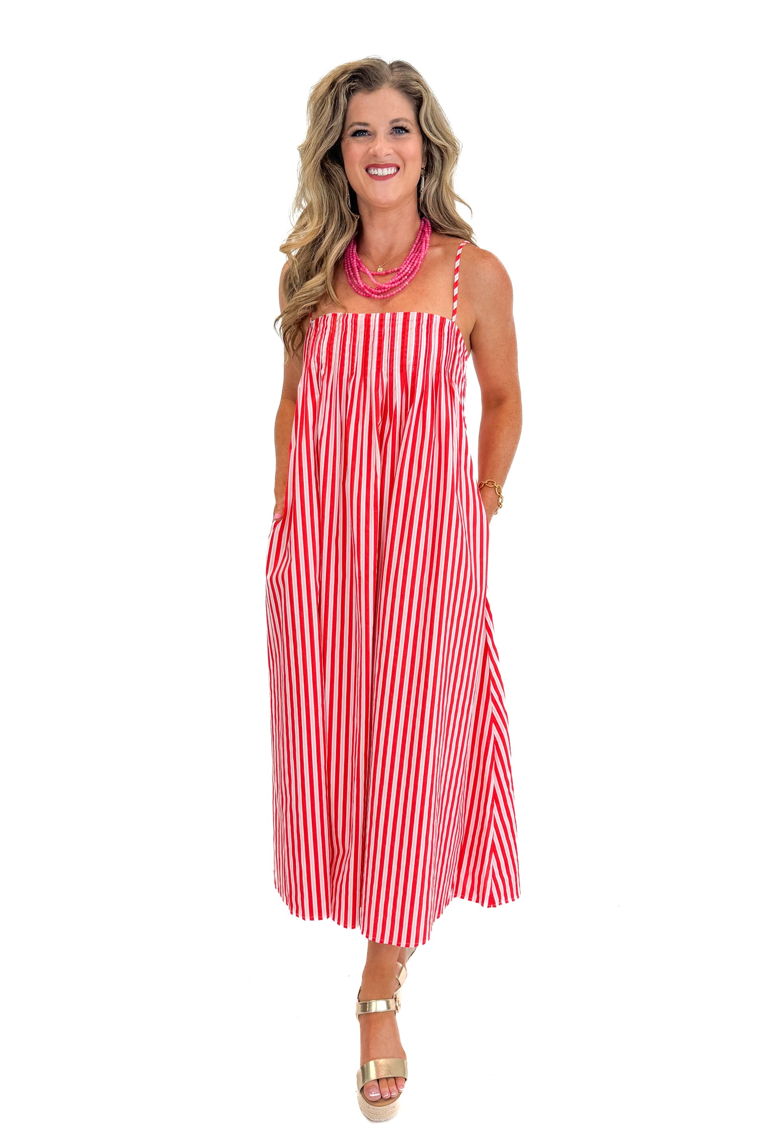 Front view of woman wearing Swagger Boutique’s Red &amp; Pink Striped Maxi Dress with sandals against white studio background.